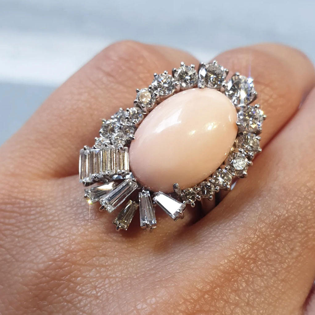 Vintage-style cocktail ring and earring set featuring oval pink coral and sapphires